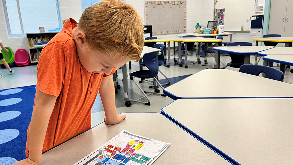 Jackson Kirkham, 6, looks at a map of the new Hardy Elementary School while checking out his first-grade classroom. The new school can accommodate nearly 30% more students. (Photo by Ryan Murphy)