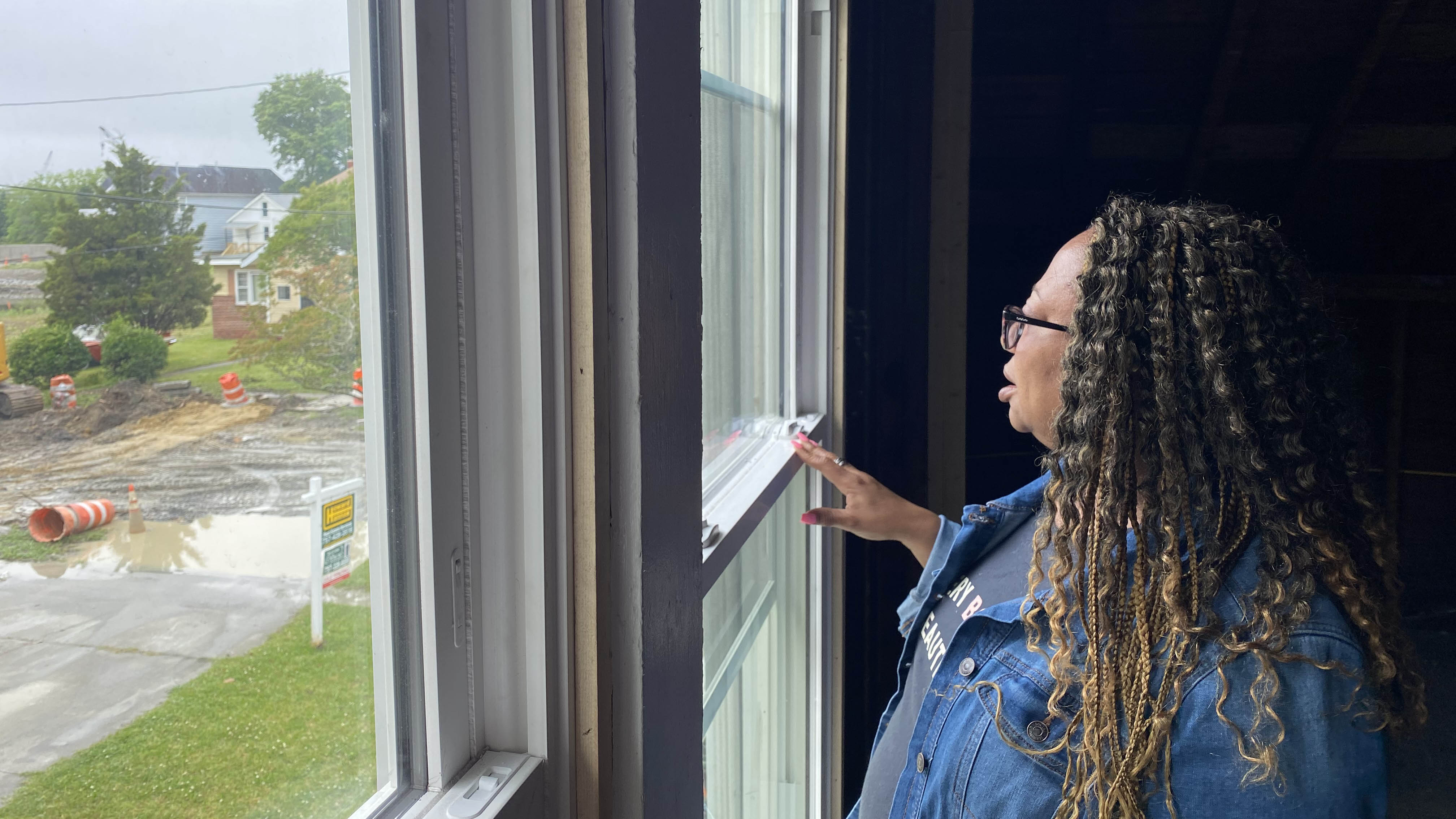 Photo by Katherine Hafner. Karen Speights looks out the window from her Chesterfield Heights home, which is undergoing renovations to test flood resilience strategies.