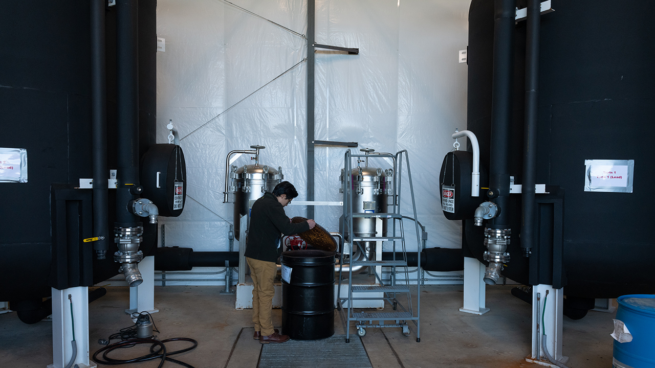 NASA restoration program manager David Liu examine the granular activated carbon filtration system designed to filter toxic PFAS chemicals from the town of Chincoteague’s drinking water on November 16, 2022.