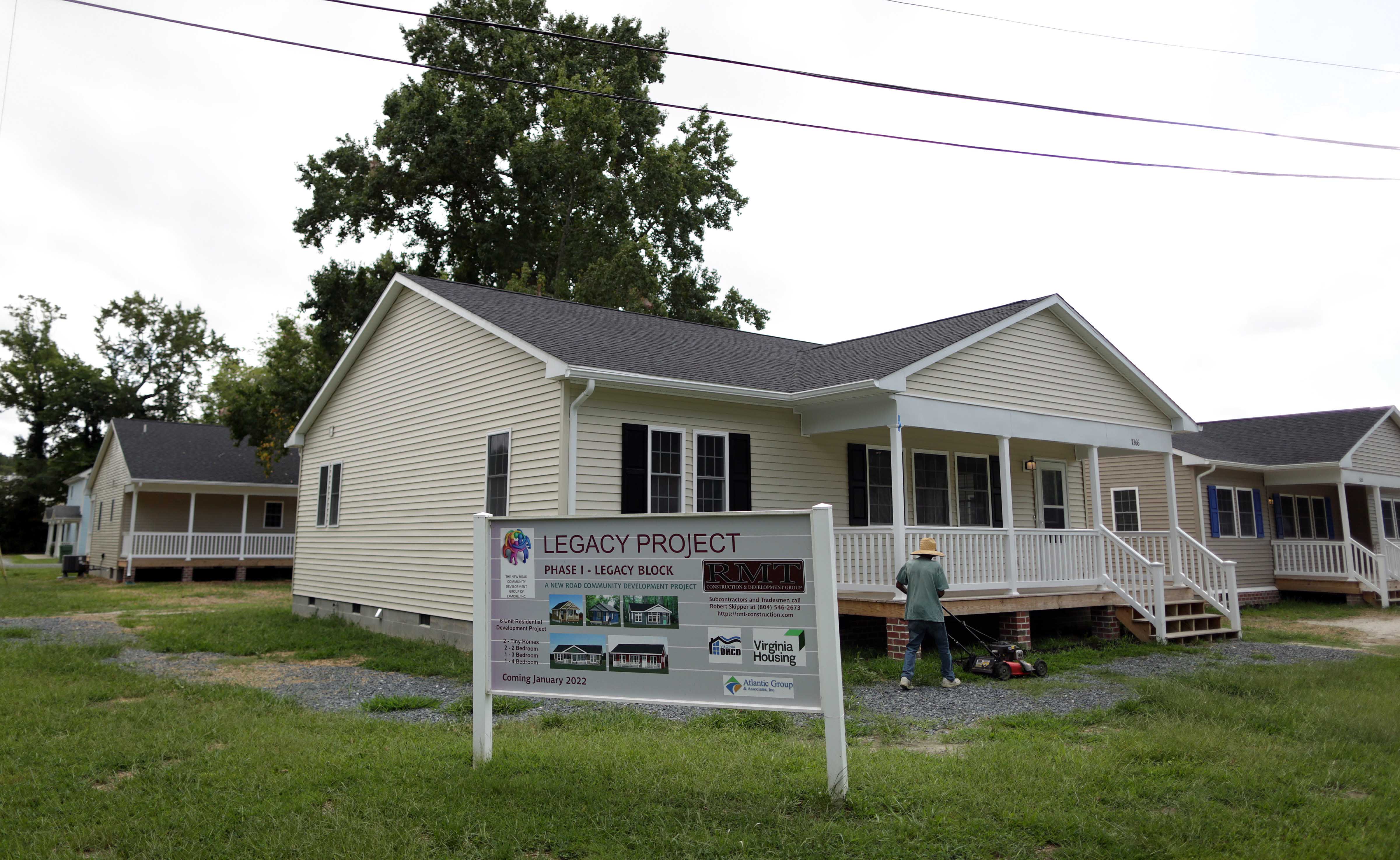 Newly built homes stand near a sign proclaiming them the  first phase of the Legacy Project, on Sept. 13, 2022, at the New Road Community, located in the Virginia Eastern Shore town of Exmore.