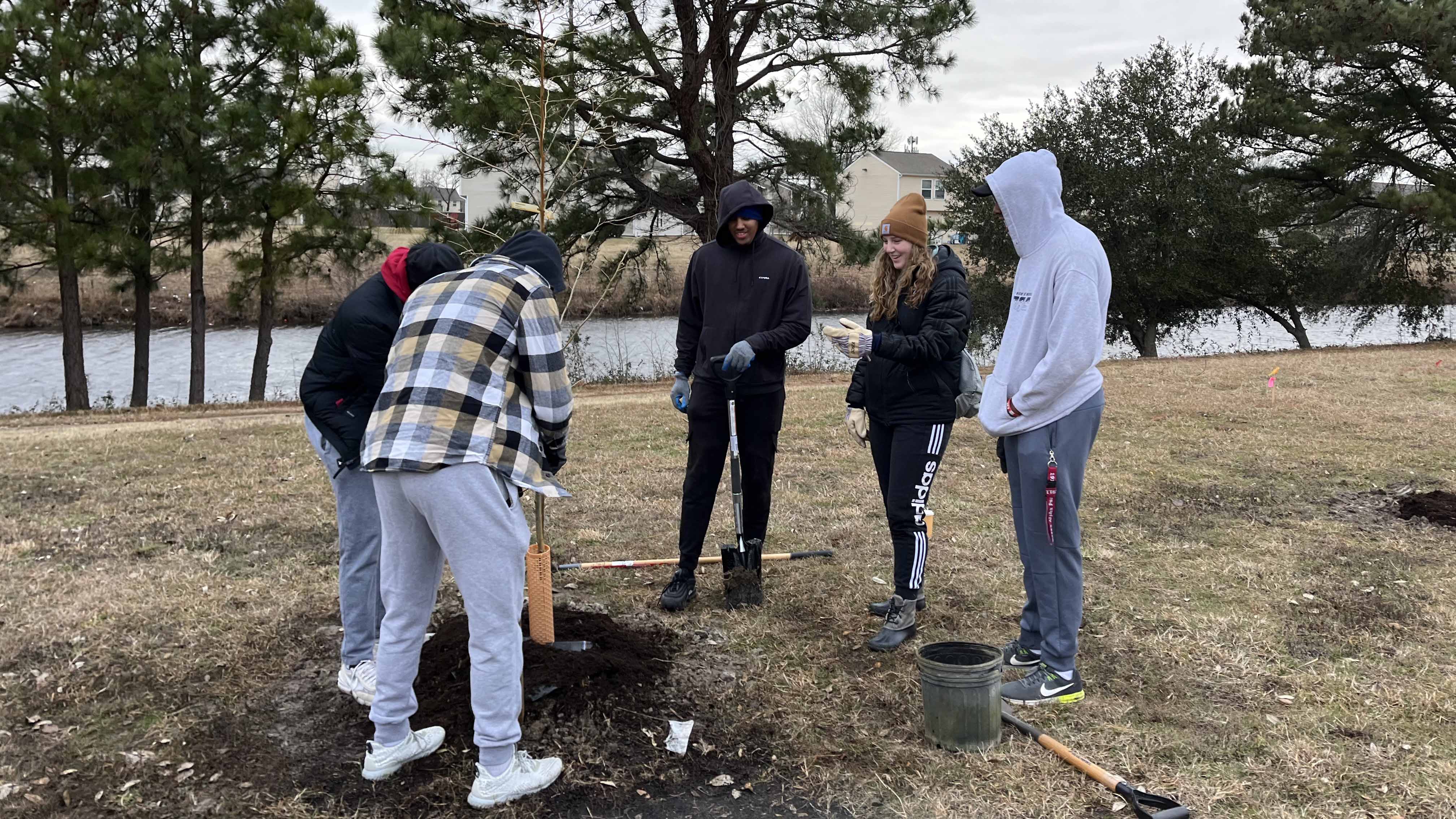 Photo courtesy of Elizabeth Malcolm. Volunteers, including Virginia Wesleyan University students, plant trees at a spot in the Green Run neighborhood identified as one of the most vulnerable in Virginia Beach to extreme heat.