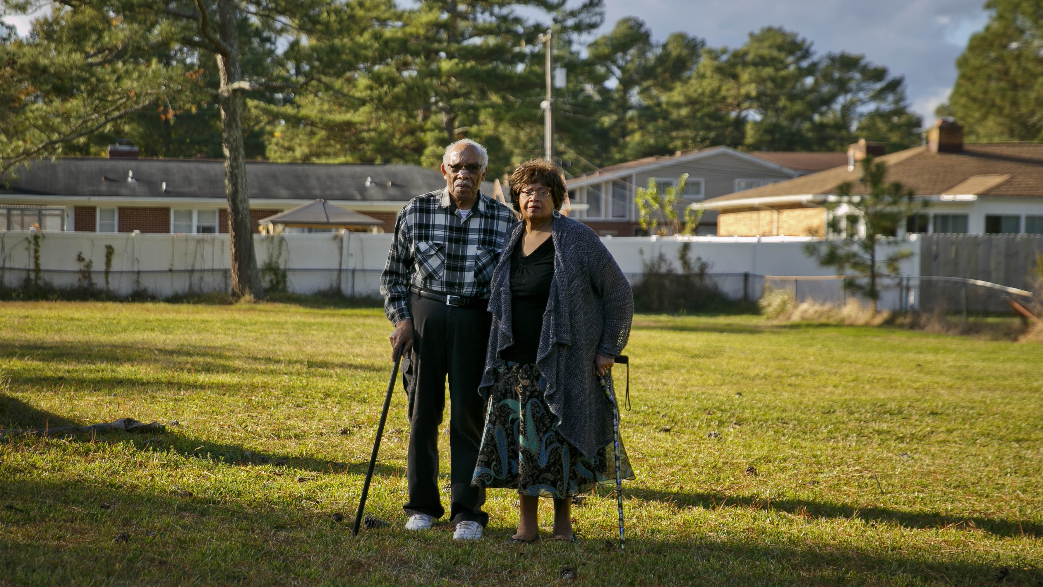 Photo by Kristen Zeis. John and Gloria Creekmur stand in the front yard of what was once their house. The Creekmurs built the home in 1968 and moved out in 2012 as part of Chesapeake’s program that buys properties that frequently flood. 